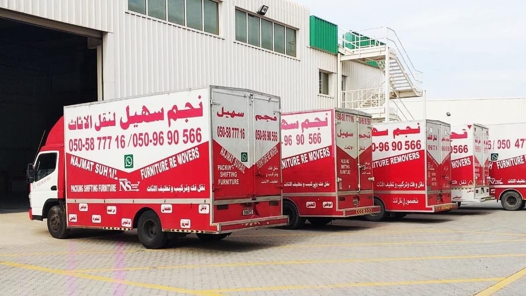 movers and packers in uae company trucks parked outside warehouse