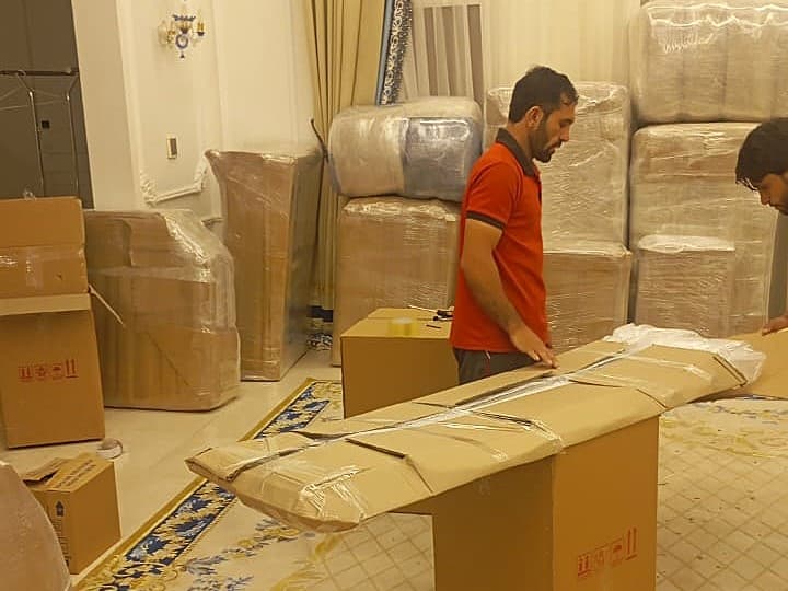 Packing services in Dubai with movers using bubble wrap and labeling boxes for secure relocation
