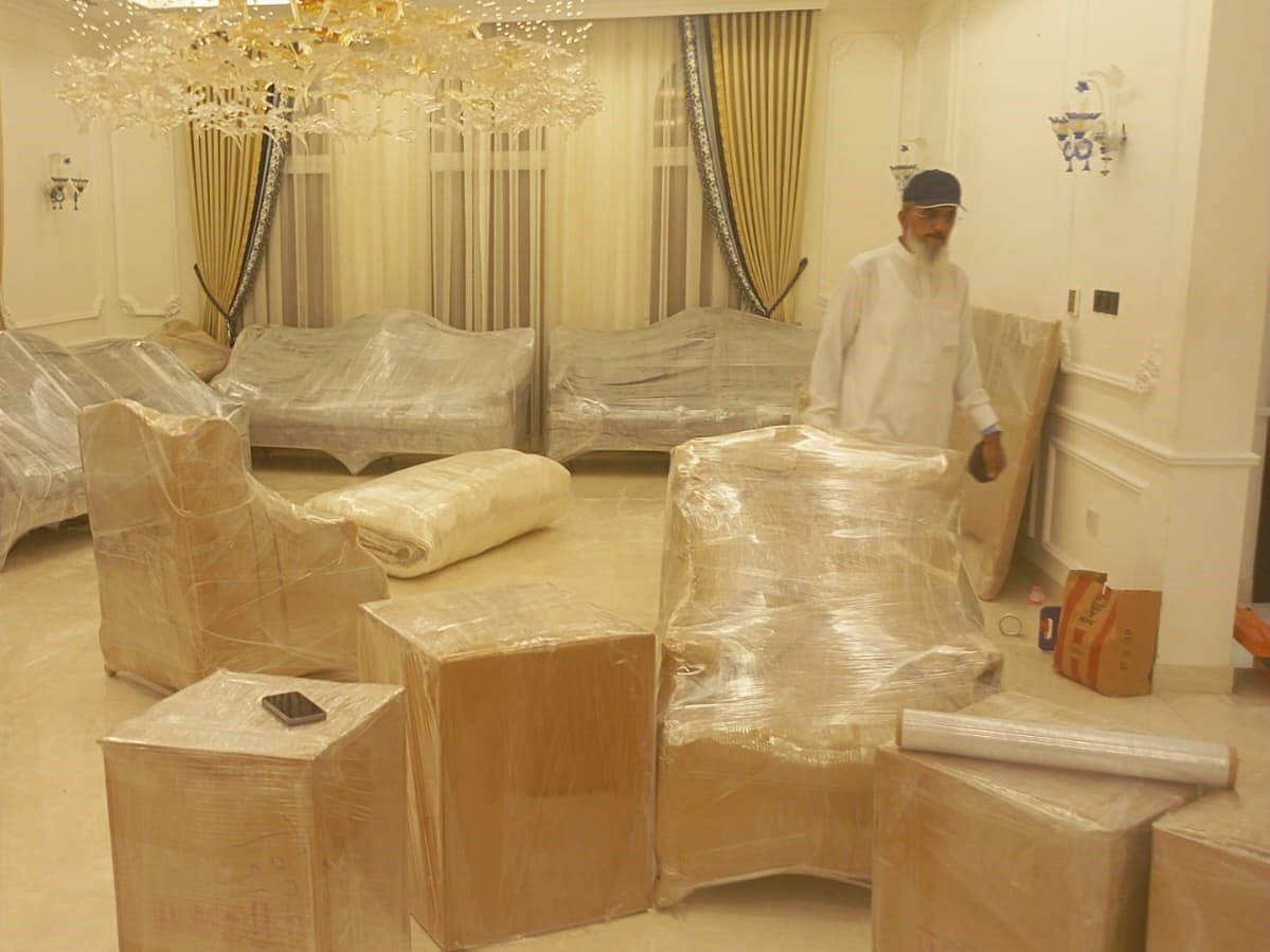 Packing services in Dubai with professional movers packing household items into boxes safely