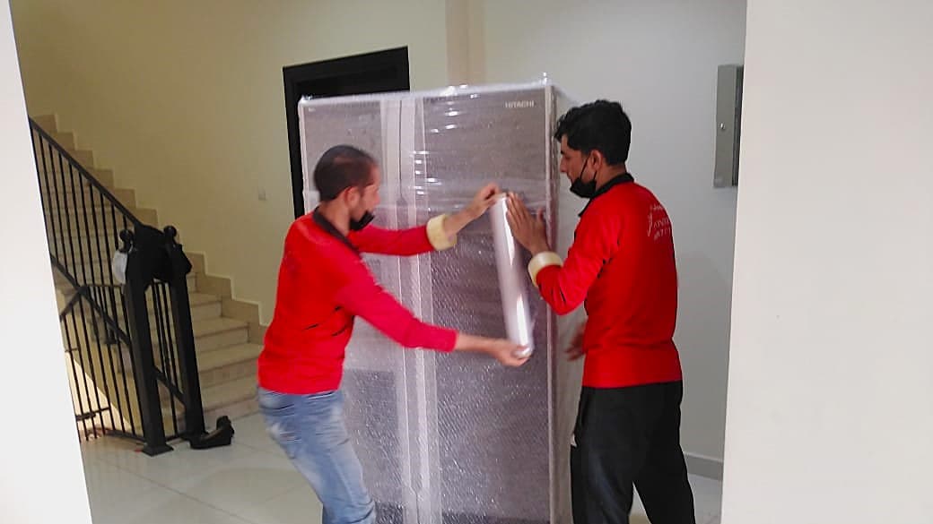 Single furniture moving team 2 members warping and packing furniture