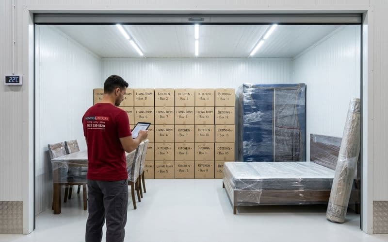 Clean organized climate-controlled storage unit with professionally wrapped furniture and labeled boxes managed by Movers and Packers UAE